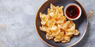 Top view of tempura pieces on a plate, with a small dipping sauce bowl, meal photography photo