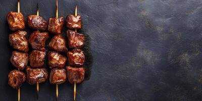 Grilled meat chunks on a skewer, lying horizontally on a flat surface, food setting photo
