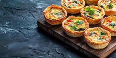 Mini quiches symmetrically arranged on a rectangular board, food setting photo