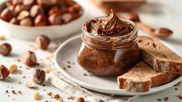 Glass jar of hazelnut spread with dollop on slice of bread on white plate, culinary photography photo