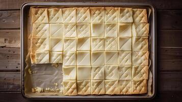 Sheet cake with a simple pattern, partially cut into squares, on a rectangular tray, culinary photography photo