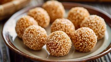 Crispy sesame balls with uniform golden color on a plain plate, food photography photo