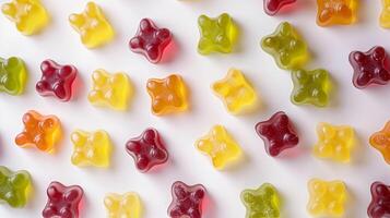 Gummy candies of different shapes and colors spread out on a clean white background, culinary photography photo