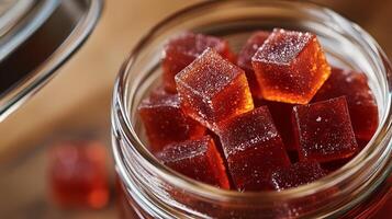 Close-up of chili gummy squares in a glass jar, lid partially open, gastronomy photography photo