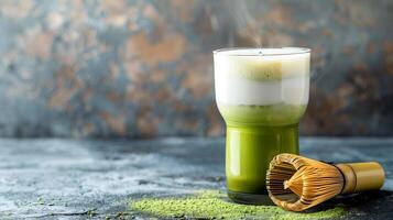 Glass of matcha latte with layers of green tea and milk next to a bamboo whisk, photorealistic food photo
