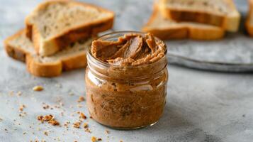 Jar of nut-free spread with the lid removed, beside a slice of toasted bread, gastronomy photography photo