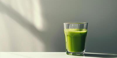 Transparent glass filled with green vegetable juice blend on plain white surface, photorealistic food photo