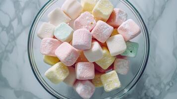 Marshmallows of various colors and shapes in a glass bowl, with visible specks, gastronomy photography photo