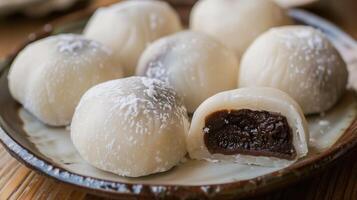 Close-up of mochi cakes with one cut open revealing its filling, on a plate, food setting photo