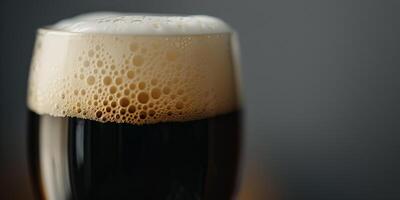 Close-up shot of a stout beer's creamy head in a clear pint glass, food setting photo