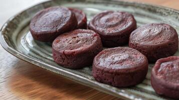 Set of red bean cakes with consistent shape and color on a dish, meal photography photo