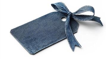 A denim tag with a ribbon tied in a bow rests on a white surface, showcasing a simple yet elegant design. photo