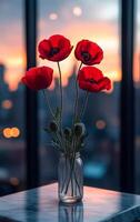 A vase of red flowers sits on a table. The flowers are in a clear glass vase and are arranged in a way that they are all facing the same direction. The vase is placed on a table in front of a window photo