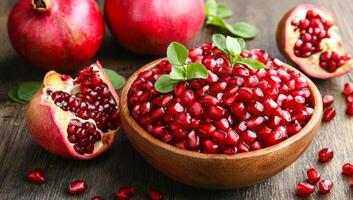 A bowl of red fruit with a few pieces missing. The bowl is on a wooden table. The fruit is ripe and ready to eat photo