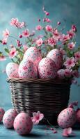 A basket filled with a variety of pink and blue eggs, each with a unique floral design. The basket is surrounded by a bed of pink flowers, creating a beautiful and whimsical display photo