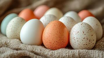 A bunch of eggs with different colors and spots on them. The eggs are arranged in a circle on a cloth photo