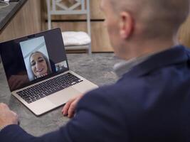 Businessman using laptop for conference with colleagues while working remotely from home office. Embracing technology for seamless communication and collaboration in modern business environment photo