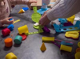 Mom and daughter enjoy quality time engaging in creative play with play-doh making colorful waffles and ice cream, Play-doh and various molds tools create fun and imaginative moments together. photo