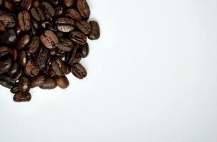 Pile of arabica coffee beans isolated on horizontal white background with empty copy space for text. photo