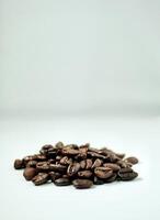 Handful of brown aromatic coffee beans isolated on vertical white background with empty copy space for text. photo