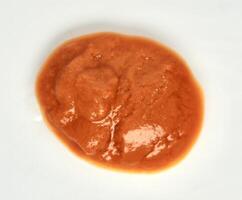 Hot chili sauce or saus sambal red food condiment isolated on white background from above angle view. photo