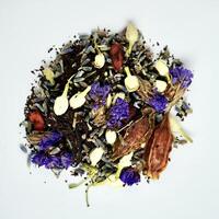 Pile of mixed organic earl grey tea, jasmine buds, lavender, gardenia, goji berry, and forget me not flowers isolated on square white background from above angle view. photo