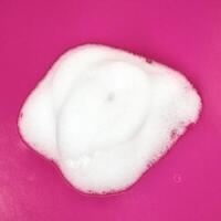 Foamy hand wash swatch texture isolated on square pink colored background from above angle view. photo