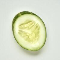 Fresh and healthy cucumber vegetable slice isolated on square white background from above angle view. photo