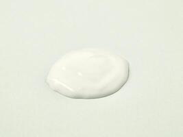 White lotion cream drop texture isolated on horizontal white background. photo