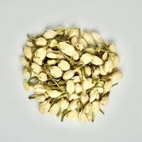Pile of dried jasmine flower buds for aromatheraphy and tea ingredients isolated on square plain background from above angle view. photo