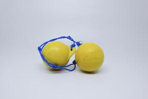 Two yellow balls with blue string tied to them photo