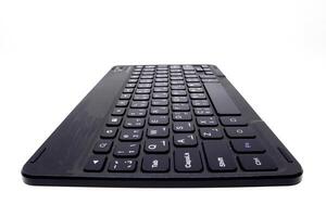 A black wireless keyboard on a white surface photo