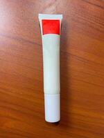 A tube of cream with a red label on top photo