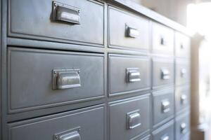 Metallic drawers with silver handles, sunlight filtering through soft blurred background photo