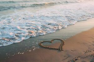 Tranquil beach scene with heart shaped imprint in sand, gentle waves washing up photo
