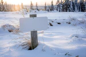 Wooden post with a blank sign in a serene snow covered landscape photo