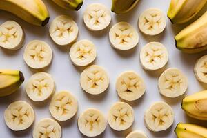 Multiple banana slices arranged in a star like pattern on a white background photo