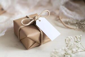 Rustic wrapped gift box tied with rope, placed on a light colored surface photo