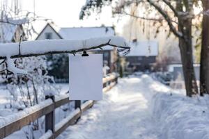 Blank paper on snowy branch, serene winter landscape with warm sunlight glow photo