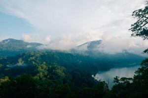 Top aerial view of a beautiful Buyan Lake, a tropical paradise, palm trees, exotic trees, and mountains in Bali photo