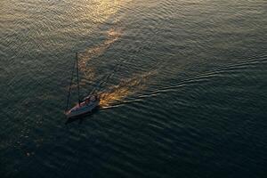 Aerial view of the boat in clear blue water at sunset in summer. Vancouver, canada photo