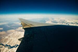 Aerial photo of the landscape with clouds, snowy mountains and view stretching all the way to the horizon