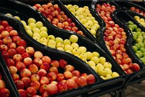 apples in the supermarkBunch of red and yellow apples on boxes in supermarketet photo