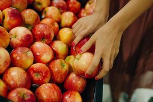 apples in the supermarkBunch of red and yellow apples on boxes in supermarketet photo
