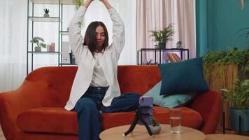 Girl blogger looks at device screen taking selfie on smartphone make virtual dance content video