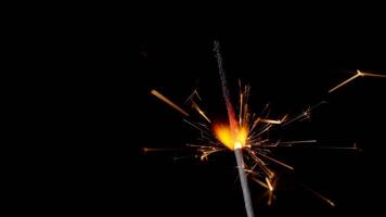 Bengal fire, New Year sparkler candle, sparkling lights burning on a black background, slow motion video