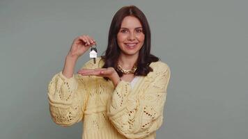 Pretty woman real estate agent showing keys of new home house apartment, buying renting property video