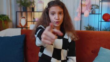 Preteen girl smiling, pointing to camera, choosing lucky winner, indicating inviting approve at home video