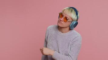 Young happy woman in headphones listening music dancing disco having fun relaxing on christmas party video