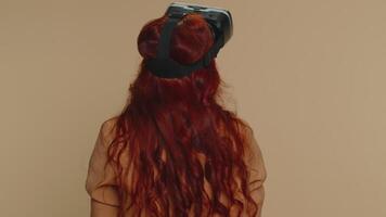 Young woman using virtual reality headset helmet to play simulation game app, watching content video